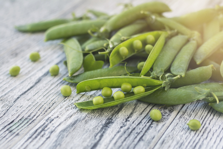 Green pea on wooden table in sunlight.の写真素材