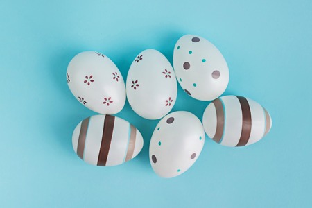 Eggs decorated with stripes and flowers on pasel blue background.の写真素材