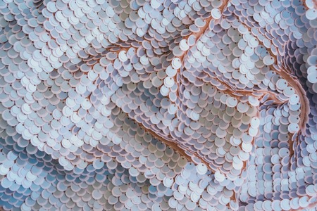 Pale pink shiny fabric with sequins, abstract background. Close-up.の写真素材