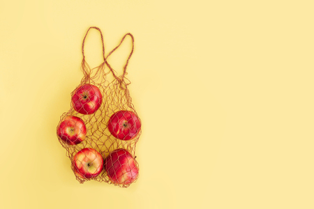 Natural eco bag with fruits on yellow background. Zero waste shopping and plastic free concept. Eco friendly, flat lay.の写真素材
