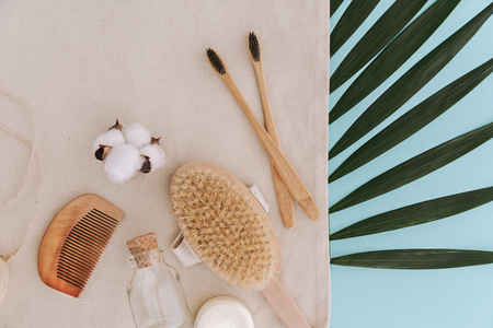 Soap, bamboo toothbrushes, natural brush, cosmetics products and tools on palm leaf. Zero waste and plastic free concept. Sustainable lifestyle concept.の写真素材