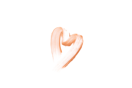 Beige smear of foundation heart shaped. Cosmetics concept isolated on white background. Top view.の写真素材
