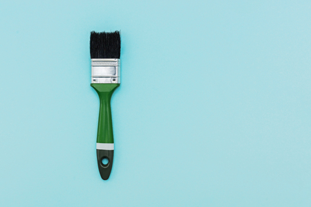 Green painting brush on blue color background with copy space.の写真素材