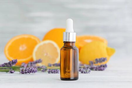Bottle with citrus natural orange, lemon and lavender essential oil on wooden background. Vitamin C.の写真素材