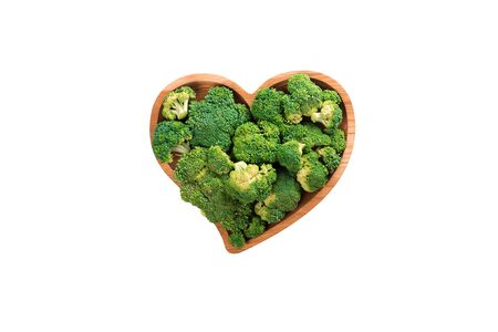 Heart shaped fresh green broccoli on wooden plate isolated on white. Top view.の写真素材