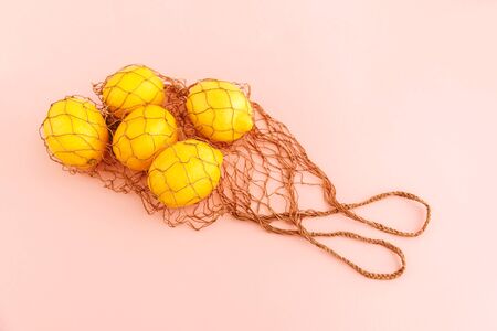 Reusable bag with lemons on pink background. Zero waste and plastic free shopping concept. Top view.の写真素材
