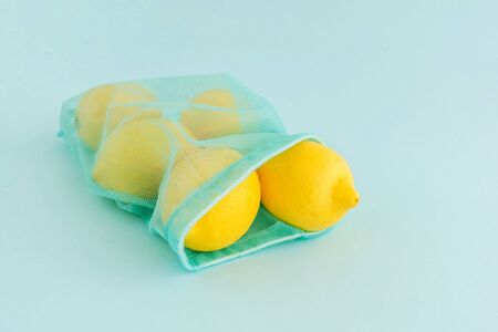 Reusable bag with lemons on blue background. Zero waste and plastic free shopping concept.の写真素材