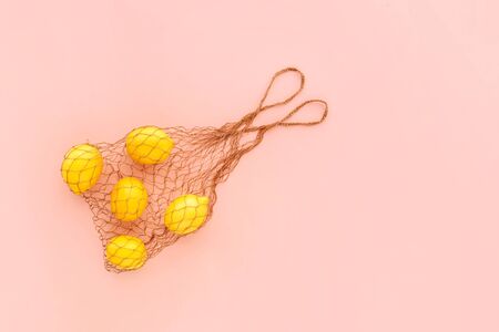 Reusable bag with lemons on pink background. Zero waste and plastic free shopping concept.の写真素材