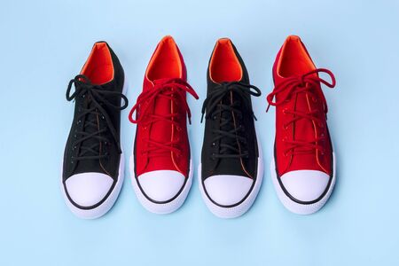 New red and black sneakers on blue background with copy space.の写真素材