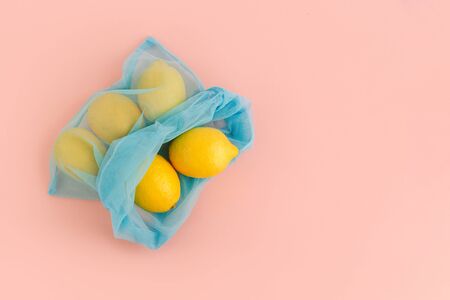 Reusable bag with lemons on pink background. Zero waste and plastic free shopping concept.の写真素材