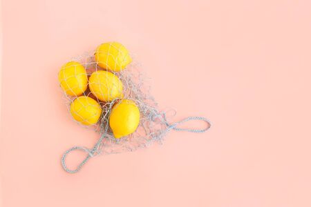 Reusable bag with lemons on pink background. Zero waste and plastic free shopping concept.の写真素材