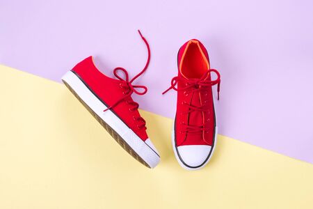 New red sneakers on yellow and violet background with copy space.の写真素材