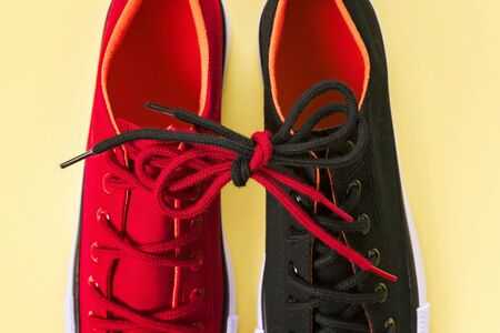 New red and black sneakers on yellow background with copy space.の写真素材