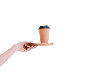Paper coffee cup to go on tray in woman's hand isolated on white. Mock up. Copy space.の写真素材