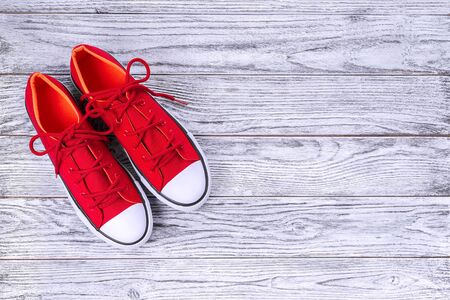 New red sneakers on wooden background with copy space. Top view.の写真素材