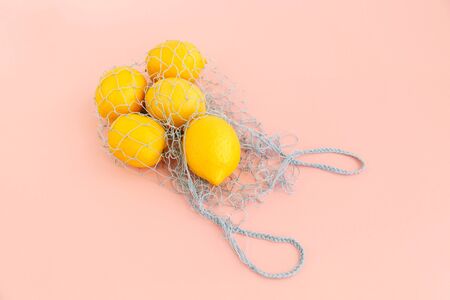 Reusable bag with lemons on pink background. Zero waste and plastic free shopping concept. Top view.の写真素材