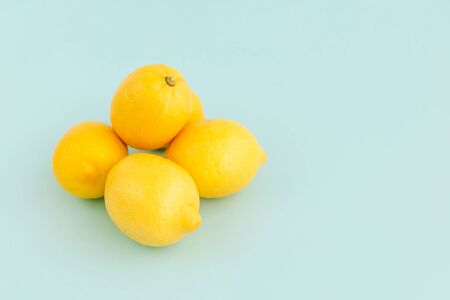 Pile of ripe yellow lemons on pale blue backgrounds. Copy space.の写真素材