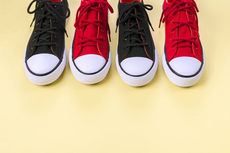 New red and black sneakers on yellow background with copy space. Top view.の写真素材