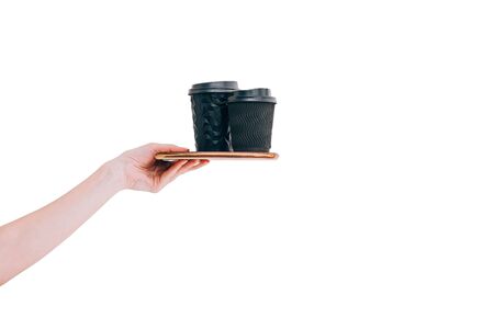 Two black paper coffee cups to go on tray in woman's hand isolated on white. Mock up. Copy space.の写真素材