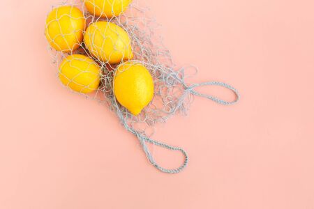 Reusable bag with lemons on pink background. Zero waste and plastic free shopping concept. Top view.の写真素材