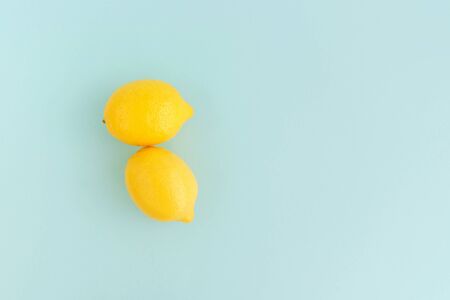 Two ripe yellow lemons on pale blue backgrounds. Copy space.の写真素材