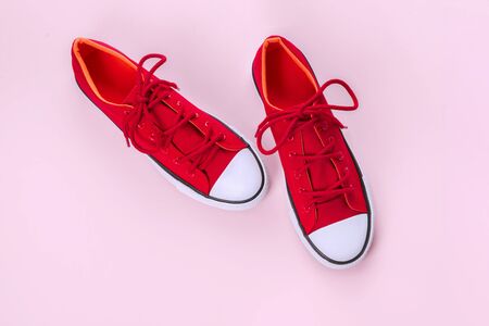 New red sneakers on pink background with copy space. Top view.の写真素材
