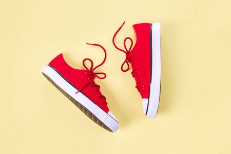 New red sneakers on yellow background with copy space. Top view.の写真素材