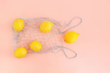 Reusable bag with lemons on pink background. Zero waste and plastic free shopping concept. Top view.の写真素材