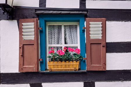 Vintage blue window on the white wall with basket of pink flowers. Old texture.の写真素材