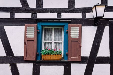 Vintage blue window on the white wall with basket of pink flowers. Old texture.の写真素材