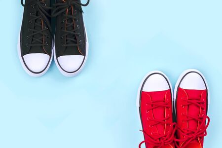 New black and red sneakers on pale blue background with copy space. Top view.の写真素材