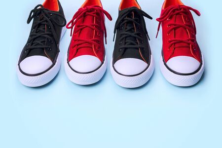 New black and red sneakers on pale blue background with copy space.の写真素材