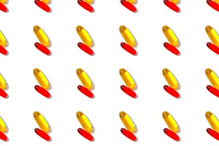 Red and yellow pills pattern isolated on white background.の写真素材