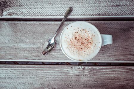 White cup of cappuccino on the grey wooden table with copy space. Top view.の写真素材