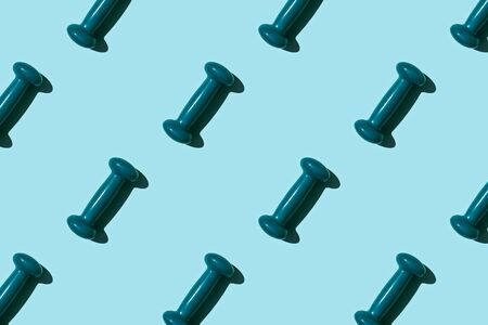 Turquoise dumbbell pattern on blue background. Creative sports layout. Top view.の写真素材