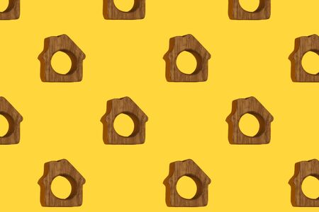 Little wooden houses creative pattern on yellow background. Top view.の写真素材