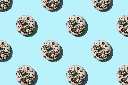 White and chocolate donut pattern on blue pastel background. Creative layout.の写真素材