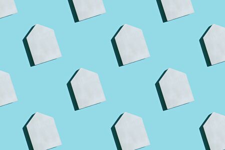 White wooden toy house pattern on blue pastel background. Creative layout. Top view.の写真素材