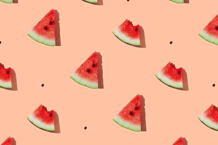 Watermelon pattern made of sliced watermelon on coral pink background. Flat lay, top view.の写真素材