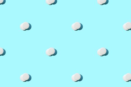 Pattern made of a lot of white round pills on blue. Medical background.の写真素材