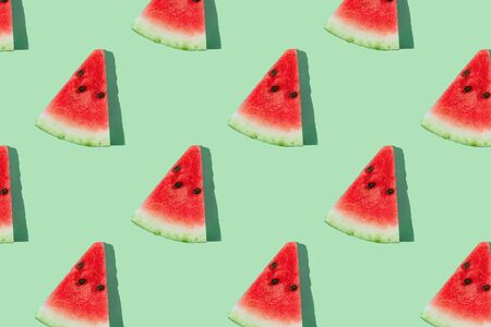 Watermelon pattern made of sliced watermelon on mint green background.の写真素材