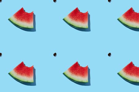 Watermelon pattern made of sliced watermelon on blue background. Flat lay, top view.の写真素材
