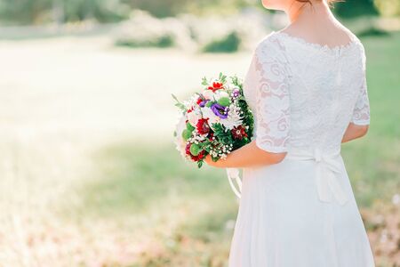 Hands of bride with wedding beautiful bouquet of white, purple and pink flowers. Cropped.の写真素材