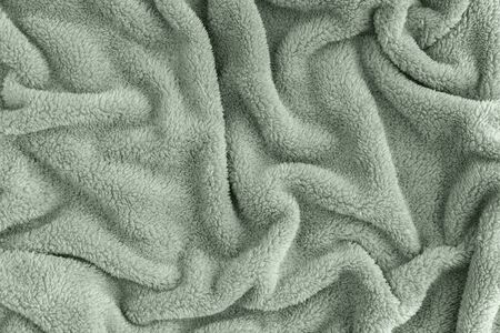 Close up top view of coral blanket wrinkled texture. Fluffy mint tranquil green background. Top view.の写真素材