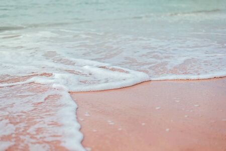 Soft green mint waves of the sea with white foam on the sandy beach.の写真素材