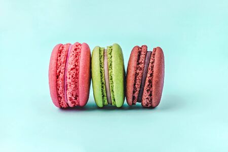 Assorted colorful macaroons on mint green background with copy space. Tasty macaroons tower.の写真素材