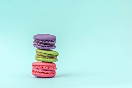 Assorted colorful macaroons on mint green background with copy space. Tasty macaroons tower.の写真素材