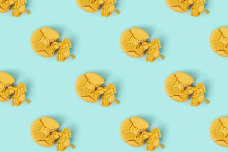 Pattern made of crushed yellow macaroons on pastel blue background. Creative layout. Top view.の写真素材