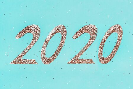 Golden sparkles shaped 2020 on green mint background. Flat lay style.の写真素材