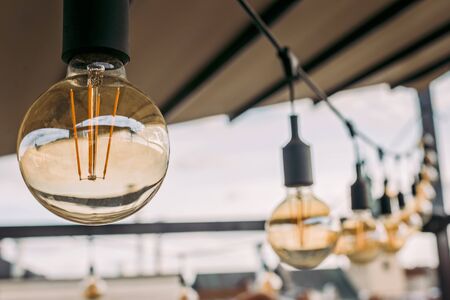 Decorative vintage sphere lamps in a row hanging from ceiling in cafe.の写真素材